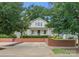 Charming home with white exterior, a brick retaining wall, and mature trees in the front yard at 2015 Lombardy Cir, Charlotte, NC 28203