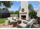 An inviting backyard boasts an outdoor white brick fireplace with a mantle and sitting area at 2015 Lombardy Cir, Charlotte, NC 28203