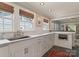 Well-lit kitchen with marble countertops, white cabinets, and stainless steel sink at 2015 Lombardy Cir, Charlotte, NC 28203