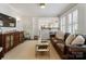 Bright living room featuring a leather sofa, decorative wall sconces, and a glass coffee table at 2015 Lombardy Cir, Charlotte, NC 28203