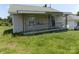 Modest home featuring a covered front porch with decorative iron railing, siding, and overgrown lawn at 212 Huffman Rd, Gastonia, NC 28052