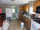 Kitchen interior with dated cabinets, appliances, and cluttered countertops; needs renovation at 212 Huffman Rd, Gastonia, NC 28052
