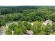 Wide aerial shot of townhouses surrounded by dense green forest, with cars parked along the street in a quiet neighborhood at 2137 Whispering Way, Charlotte, NC 28212