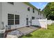A concrete back patio with a white vinyl fence and an entry door to the house is ready for outdoor entertaining at 2137 Whispering Way, Charlotte, NC 28212