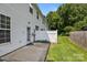 A concrete back patio is surrounded by a grassy yard with a partial view of the wooded backyard at 2137 Whispering Way, Charlotte, NC 28212