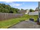 A concrete backyard patio with access to the home has grass and a wood fence at 2137 Whispering Way, Charlotte, NC 28212