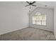 Bright bedroom with vaulted ceiling, carpeted floor, ceiling fan, and a large window at 2137 Whispering Way, Charlotte, NC 28212