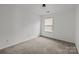 Cozy bedroom with neutral carpeting and a window providing natural light at 2137 Whispering Way, Charlotte, NC 28212