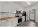 Well-equipped kitchen features white cabinets, butcher block countertops, and stainless steel appliances at 2137 Whispering Way, Charlotte, NC 28212