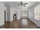 Living room features wood floors, arched doorway to kitchen, and large windows at 2137 Whispering Way, Charlotte, NC 28212