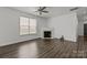 Cozy living room features a fireplace, ceiling fan, large window and wood-look flooring at 2137 Whispering Way, Charlotte, NC 28212