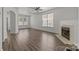 Spacious living room with a ceiling fan, wood floors, fireplace, and plenty of natural light at 2137 Whispering Way, Charlotte, NC 28212