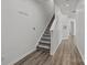 Staircase with gray carpet treads and white risers, leading to upper floor, and wood flooring at 2137 Whispering Way, Charlotte, NC 28212