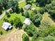 Expansive aerial view of home and barns nestled among lush greenery at 233 Hicks Rd, Statesville, NC 28625
