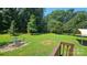 A serene backyard patio with green metal table set amidst a spacious grassy area at 233 Hicks Rd, Statesville, NC 28625