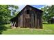 Charming rustic barn with weathered wood, set amidst a lush green lawn, showcasing its vintage appeal at 233 Hicks Rd, Statesville, NC 28625