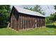 Rustic barn with weathered wood exterior and a durable metal roof, surrounded by lush greenery at 233 Hicks Rd, Statesville, NC 28625