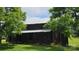 Classic weathered barn with a sturdy metal roof, nestled among mature trees and a green lawn at 233 Hicks Rd, Statesville, NC 28625