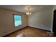 Bright dining room featuring hardwood floors, a charming chandelier, and natural light from the large window at 233 Hicks Rd, Statesville, NC 28625