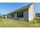 Backyard featuring a well-maintained lawn, neutral siding, and several windows illuminating the home's interior at 2407 Baxter Se Pl, Concord, NC 28025