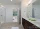 Bright bathroom with a stand-up shower, double vanity, and view of the bedroom at 2407 Baxter Se Pl, Concord, NC 28025