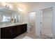 Well-lit bathroom with double vanity, dark wood cabinets, and neutral tile flooring at 2407 Baxter Se Pl, Concord, NC 28025
