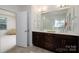 Bright bathroom with double vanity, dark wood cabinets, and shower at 2407 Baxter Se Pl, Concord, NC 28025
