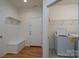 Well-organized mudroom featuring a storage bench, coat hooks, and access to the laundry area with washer and dryer at 2407 Baxter Se Pl, Concord, NC 28025