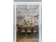 Open-concept dining room with wood table set and coffered ceilings, flowing into the kitchen with white cabinets at 252 Broadleaf Dr, Denver, NC 28037