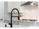 Close-up of a modern kitchen with a stainless steel range hood and white cabinetry at 252 Broadleaf Dr, Denver, NC 28037