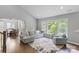 Open concept living room with dining area and comfortable seating, bathed in natural light from large windows at 252 Broadleaf Dr, Denver, NC 28037