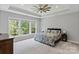 Serene main bedroom with tray ceilings, large windows overlooking a green landscape and neutral décor at 252 Broadleaf Dr, Denver, NC 28037
