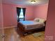 Cozy bedroom with a double bed, wooden floors, and a window with dark curtains, providing a comfortable retreat at 2721 Nance Cove Rd, Charlotte, NC 28214