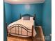Comfortable bedroom with a wrought iron bed frame, light wood floors, and blue walls offering a serene ambiance at 2721 Nance Cove Rd, Charlotte, NC 28214