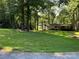 Charming single-story home nestled in a wooded area with a well-manicured lawn and serene surroundings at 2721 Nance Cove Rd, Charlotte, NC 28214