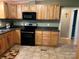 Kitchen with wooden cabinets and drawers, black appliances, and tile flooring at 2721 Nance Cove Rd, Charlotte, NC 28214