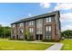 Modern townhome with brick and gray siding, sidewalk, and lush green lawn at 3006 Khan Park Dr # 69, Charlotte, NC 28206
