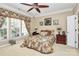 Cozy bedroom with a ceiling fan, beige walls, two bedside tables, and a window with patterned curtains at 3079 Azalea Dr, Fort Mill, SC 29707