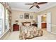 Comfortable main bedroom with an ensuite bathroom, beige walls, ceiling fan, bedside tables, and patterned curtains at 3079 Azalea Dr, Fort Mill, SC 29707
