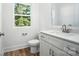 Modern bathroom featuring a white vanity, toilet and a window providing natural light at 411 Patience Dr, Concord, NC 28025