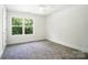 Bright bedroom features a ceiling fan, a large window, and plush carpet flooring at 411 Patience Dr, Concord, NC 28025