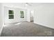 Bedroom featuring two windows, neutral carpet, and a view into an ensuite bathroom at 411 Patience Dr, Concord, NC 28025