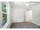 Bedroom with a large window, ceiling fan, and open door to an adjoining room at 411 Patience Dr, Concord, NC 28025