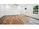 Large bedroom featuring wood-look flooring, neutral paint, and two windows for natural light at 411 Patience Dr, Concord, NC 28025