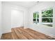 A bright bedroom with wood-look flooring, neutral paint and ample windows for natural light at 411 Patience Dr, Concord, NC 28025