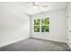 Cozy bedroom with natural light, a ceiling fan, neutral carpet, and a large window at 411 Patience Dr, Concord, NC 28025