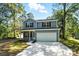 Charming two-story home featuring a covered front porch, attached garage, and well-maintained lawn at 411 Patience Dr, Concord, NC 28025