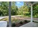 A view from the front porch overlooking the landscaped yard with mature trees in the background at 411 Patience Dr, Concord, NC 28025