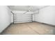 Spacious garage with a white door and concrete flooring at 411 Patience Dr, Concord, NC 28025