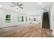 Open-concept living room featuring wood-look floors leading to a modern kitchen and staircase at 411 Patience Dr, Concord, NC 28025